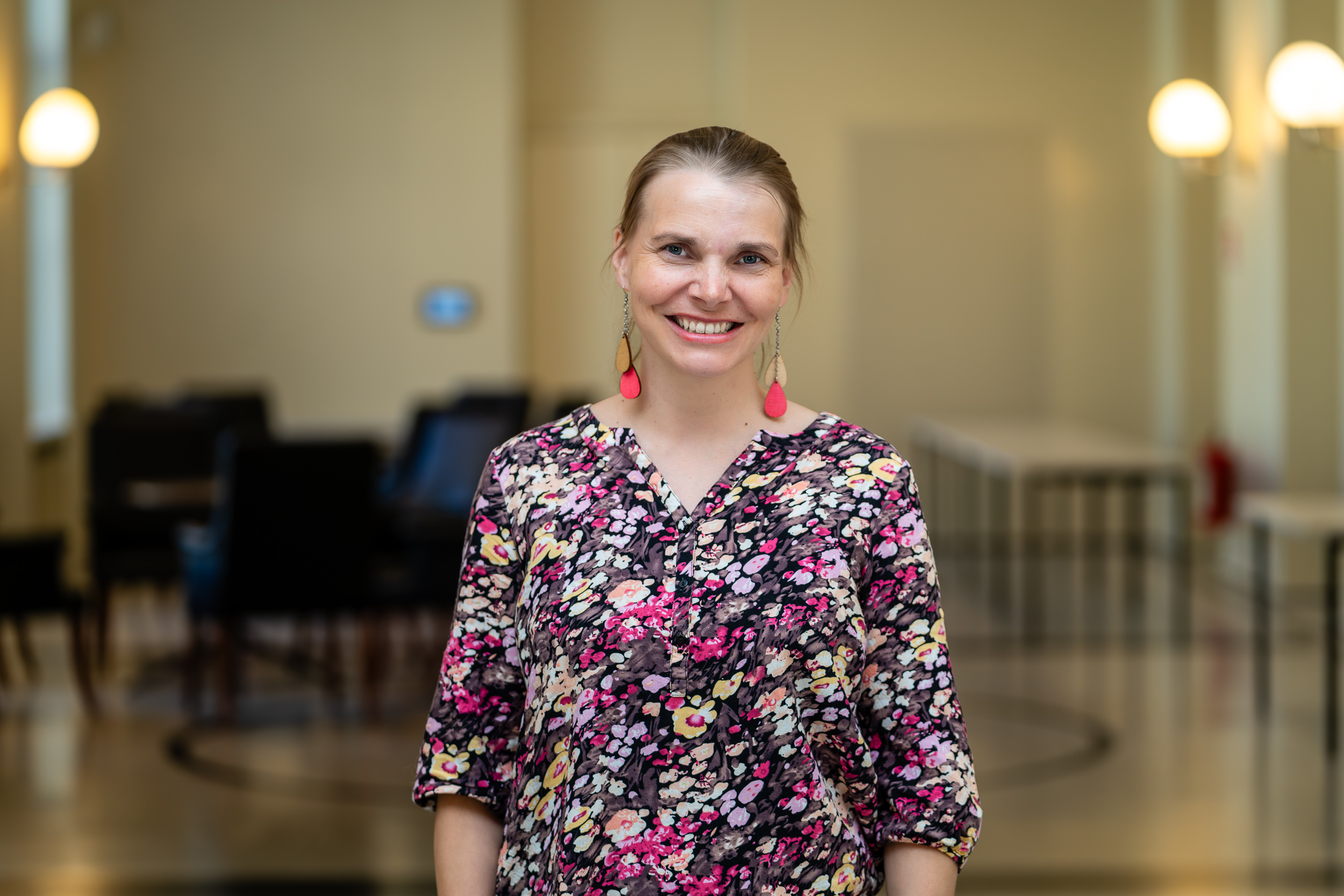 Valokuva Annista sisätiloissa. Hän hymyilee kameraa kohti.