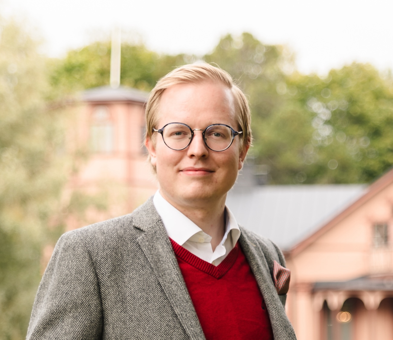 Valokuva. Toni Pakarinen seisoo Oulunkylän seurahuoneen edustalla.